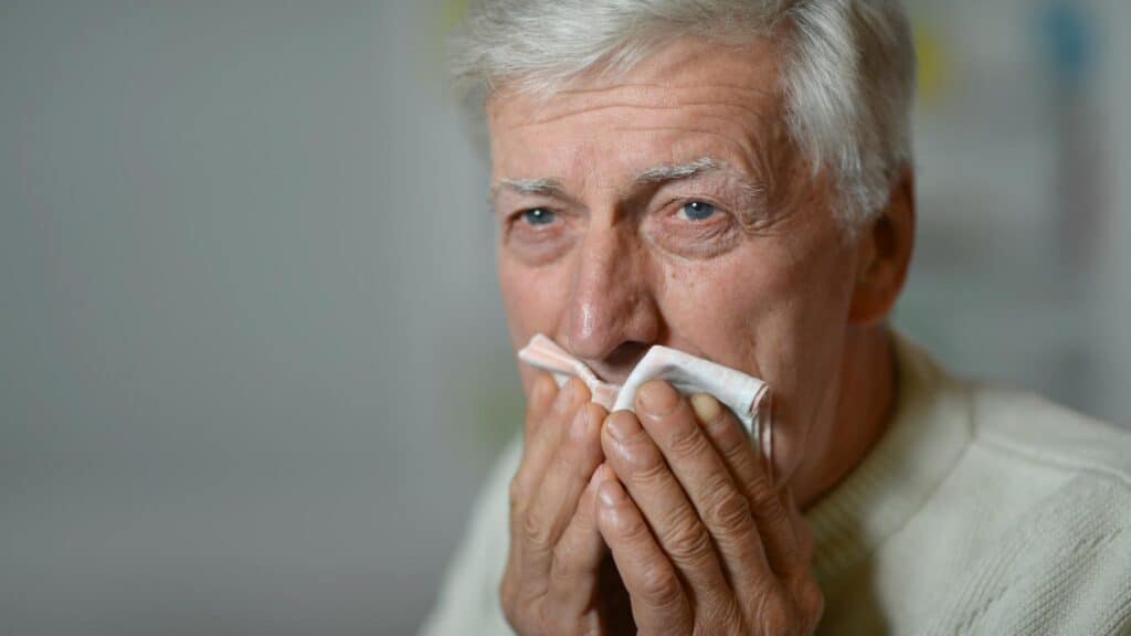 An older man cleaning off his mouth