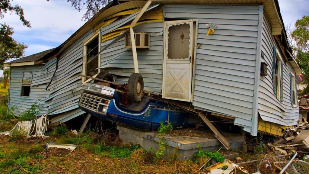 Car crashed into a house, causing structural damage and collapse.