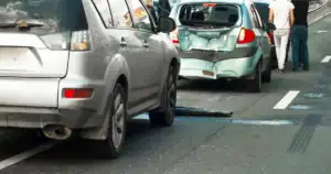Two cars involved in a collision on a Tulsa street, with witnesses nearby.
